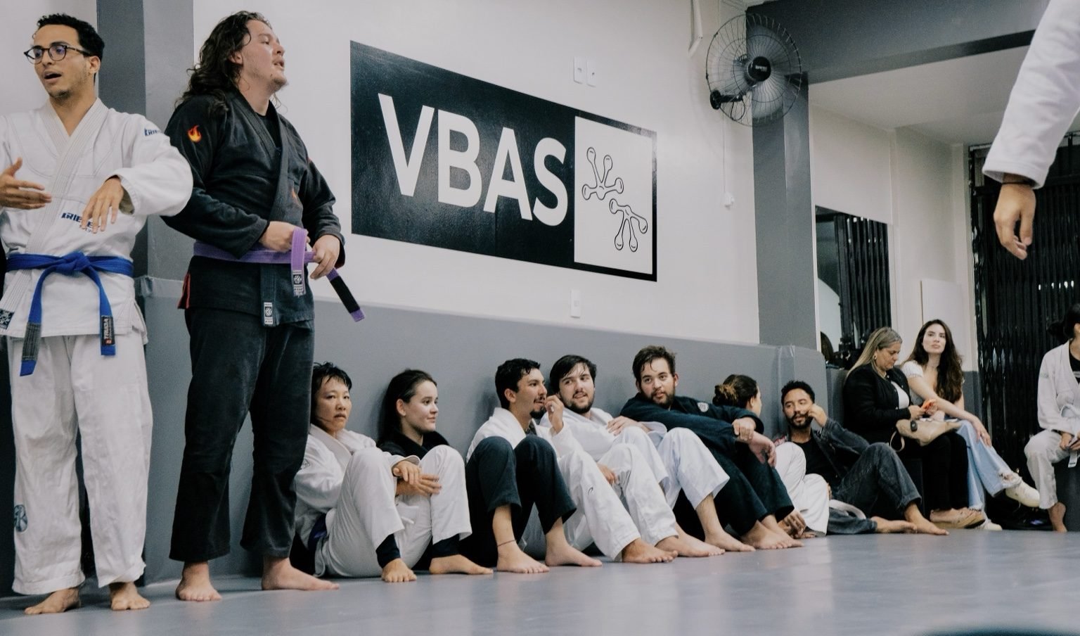 Alunos e professores enfileirados no tatame no fim da aula